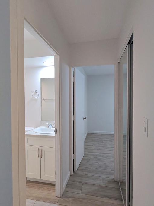 Punahou Circle bathroom with a sink, mirror, and wooden floors.
