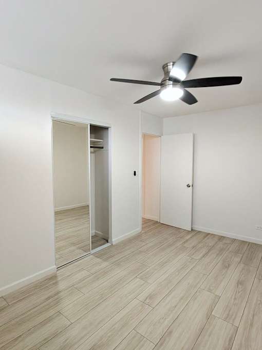 Punahou Circle bedroom with a ceiling fan and a door with a mirror on the wall.
