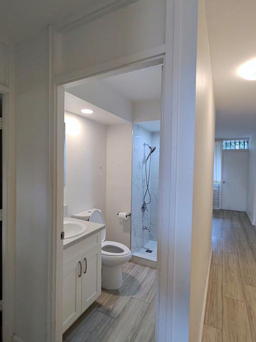 A bathroom with a toilet, sink, and shower.