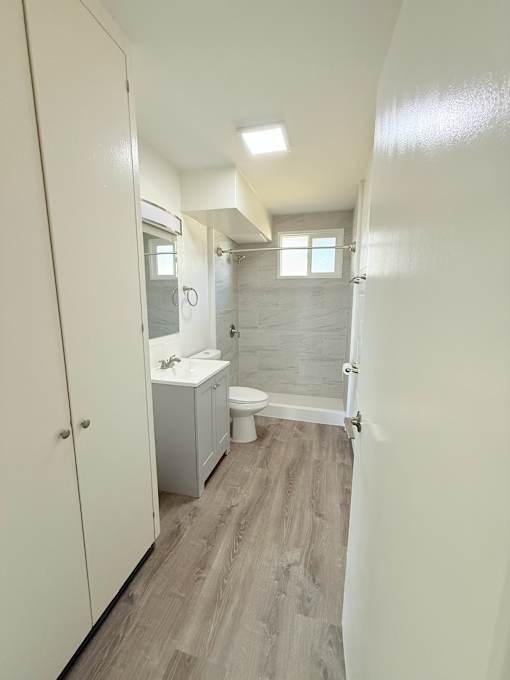 A small bathroom with a toilet, sink, and shower.