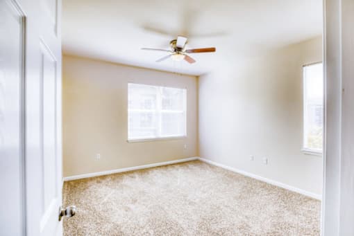 A room with a ceiling fan and a window.