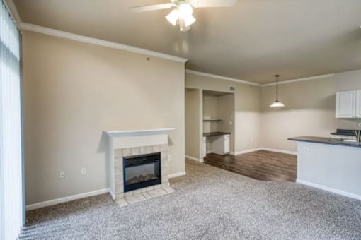 A living room with a fireplace and a ceiling fan.