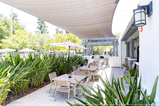 Horzons at Calabasas community patio with a table and chairs under a white awning.
