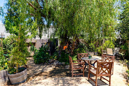 Horizons at Calabasas garden with a table and chairs under a tree.