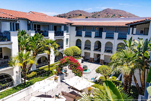 Horizons at Calabasas courtyard aerial view with a fountain surrounded by palm trees and buildings.