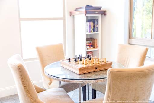 Horizons at Calabasas game room table with a chess board on the table and games on a bookshelf.