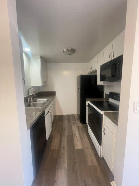 Seaview kitchen with black appliances and white cabinets.