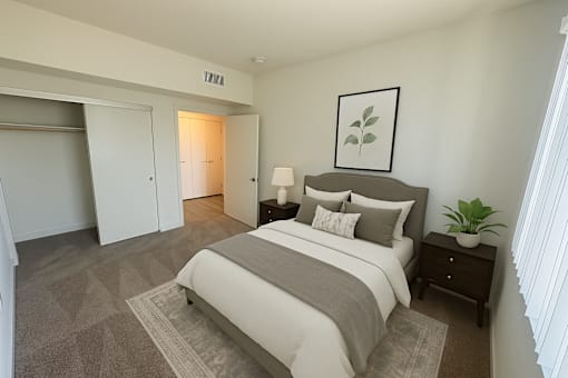 A bedroom with a large bed and a plant on the nightstand.