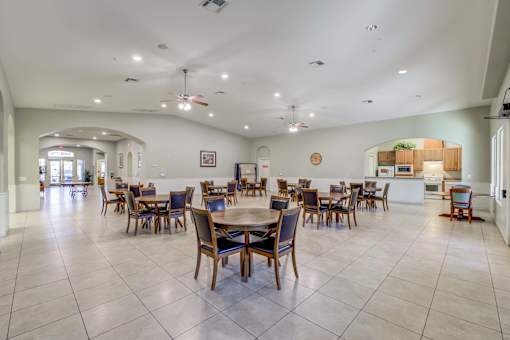 A spacious dining room with a large table and chairs.