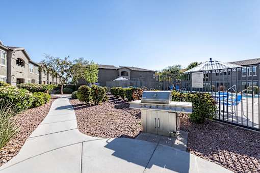 A sunny day at a residential area with a pool and a BBQ grill.