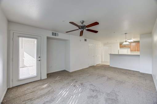 A room with a ceiling fan and carpeted floor.