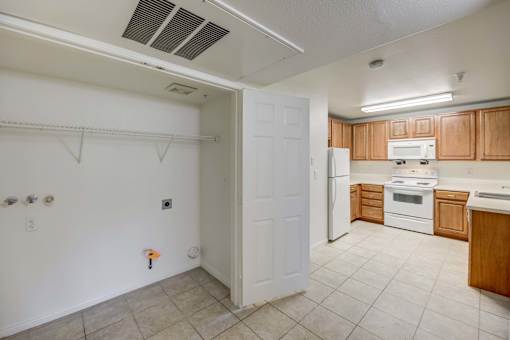 A kitchen with white appliances and wooden cabinets.