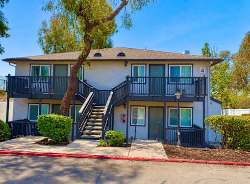 A two-story apartment building with a balcony on the second floor.