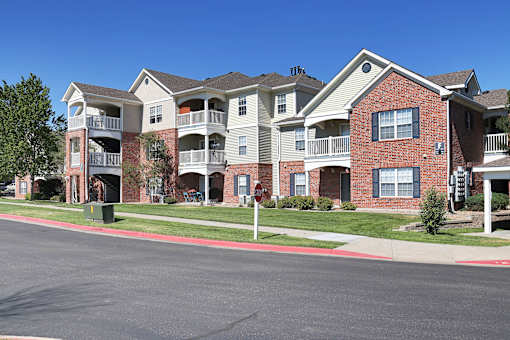 Apartment building with a red brick facade and multiple balconies.
