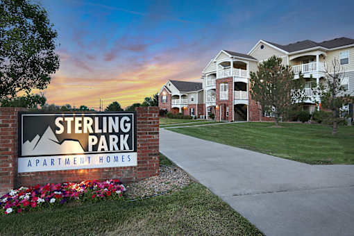 Sterling Park Apartment Homes sign with a sunset in the background.