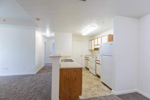 A kitchen with white appliances and wooden cabinets.