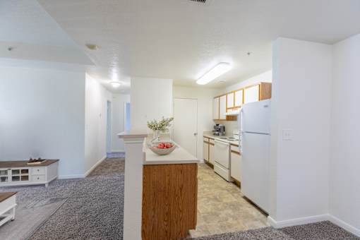A kitchen with white appliances and wooden cabinets.