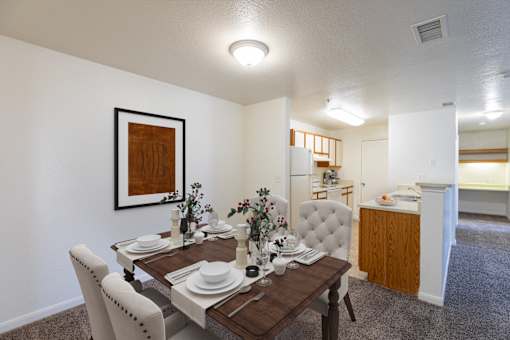 A dining room with a wooden table set for a meal.