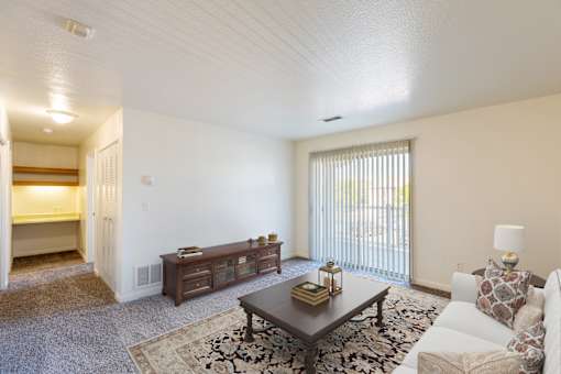 A living room with a white couch, a coffee table, and a rug.