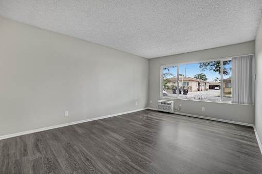 Empty room with grey walls and wooden flooring.