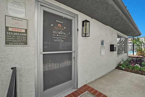 A building entrance with a glass door and a sign on the wall.