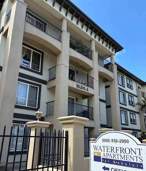 A sign for Waterfront Apartments is in front of a building.