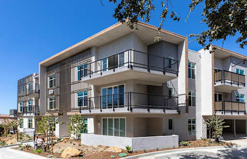 A modern apartment building with balconies and multiple stories.