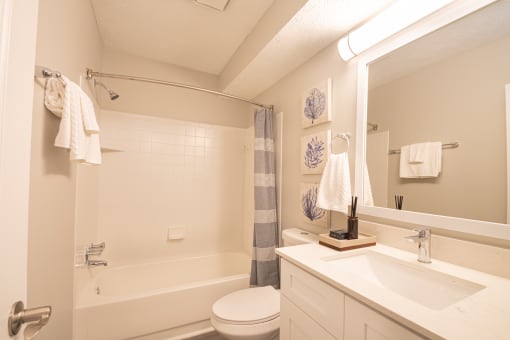 a bathroom with a white bathtub and a white sink with a mirror above it