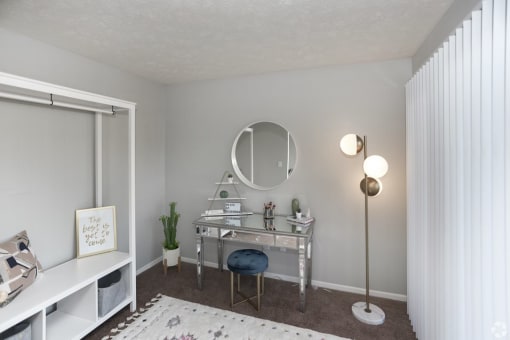 a bedroom with a vanity and a mirror