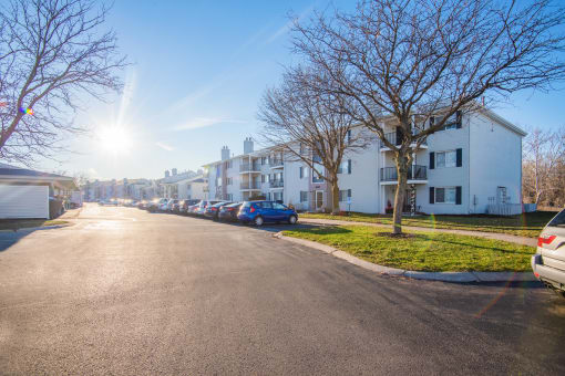 a street with cars parked in front of apartment buildings