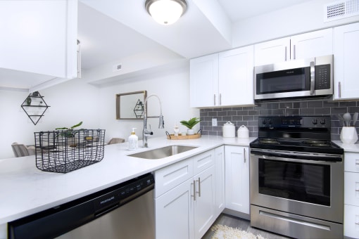 a kitchen with stainless steel appliances and white cabinets