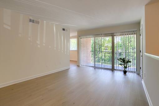 A room with a sliding glass door leading to a balcony.