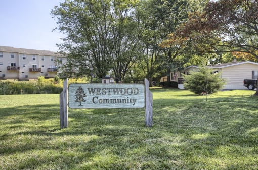 a sign that says westwood community with houses in the background
