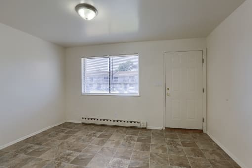 the living room of an empty house with a window and a door