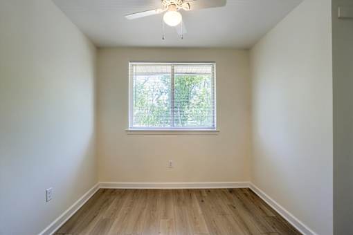 A room with a window and a ceiling fan.