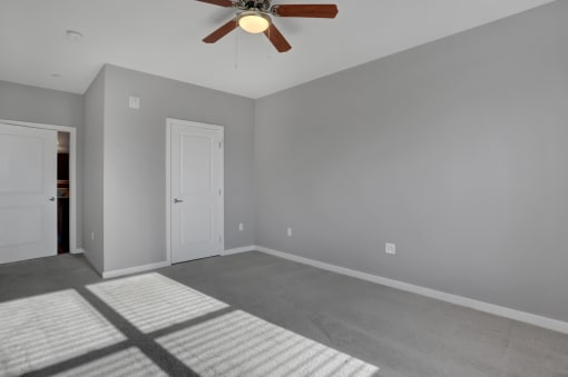 a bedroom with grey walls and a ceiling fan | Centerpointe Apartments in Camp Hill