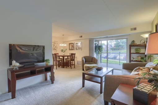 Apartments in Harrisburg | Twin Lakes Apartments | a living room with a television and a dining room in the background