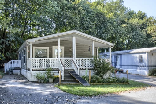 a small house with a porch in a campsite
