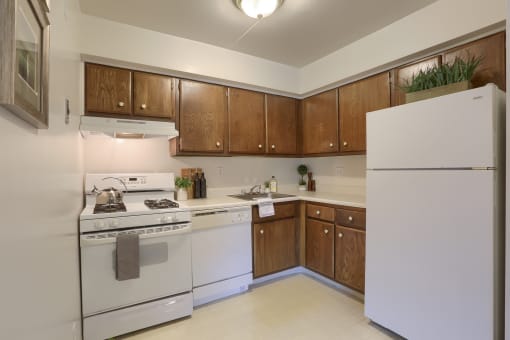 Apartments in Harrisburg | Twin Lakes Apartments | a kitchen with white appliances and wooden cabinets