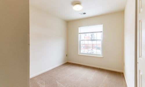 A room with a window and carpeted floor.