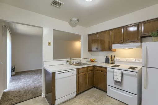 an empty kitchen with white appliances and wooden cabinets