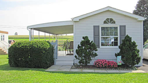 A house with a grey siding and a white roof.
