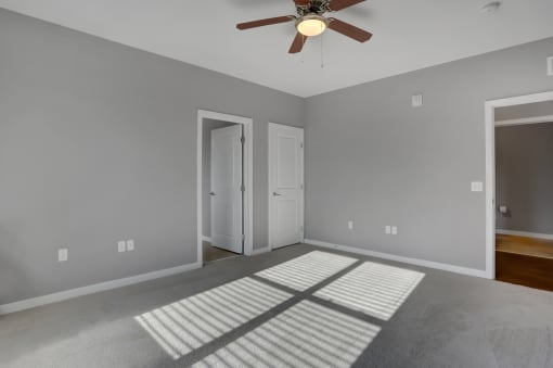 a bedroom with gray walls and a ceiling fan | Centerpointe Apartments in Camp Hill