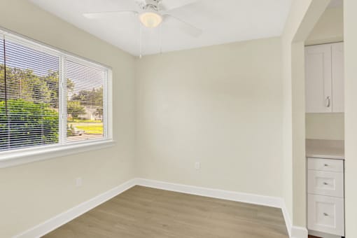 A room with a window and a ceiling fan.