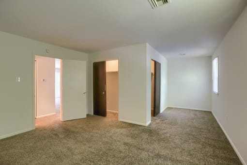 an empty living room with white walls and carpet