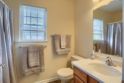 A bathroom with a toilet, sink, and towel rack.