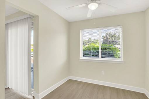 A room with a window and a ceiling fan.