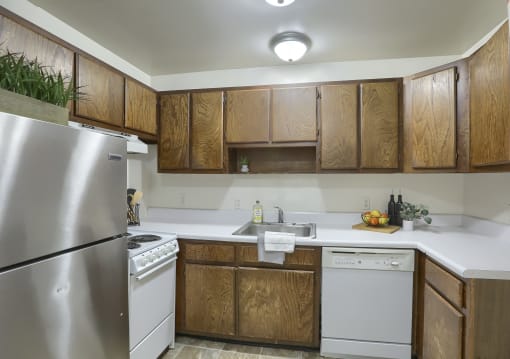an empty kitchen with white appliances and wooden cabinets