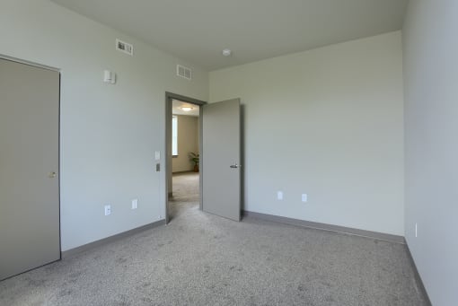 Mount Joy Senior Housing | a bedroom with a carpeted floor and a door that leads to a hallway