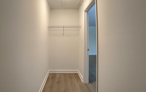 A room with a door and a coat rack.